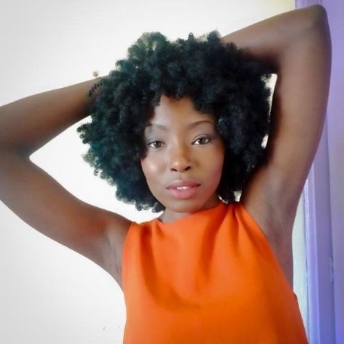 woman with underarms showing in a orange sleeveless top