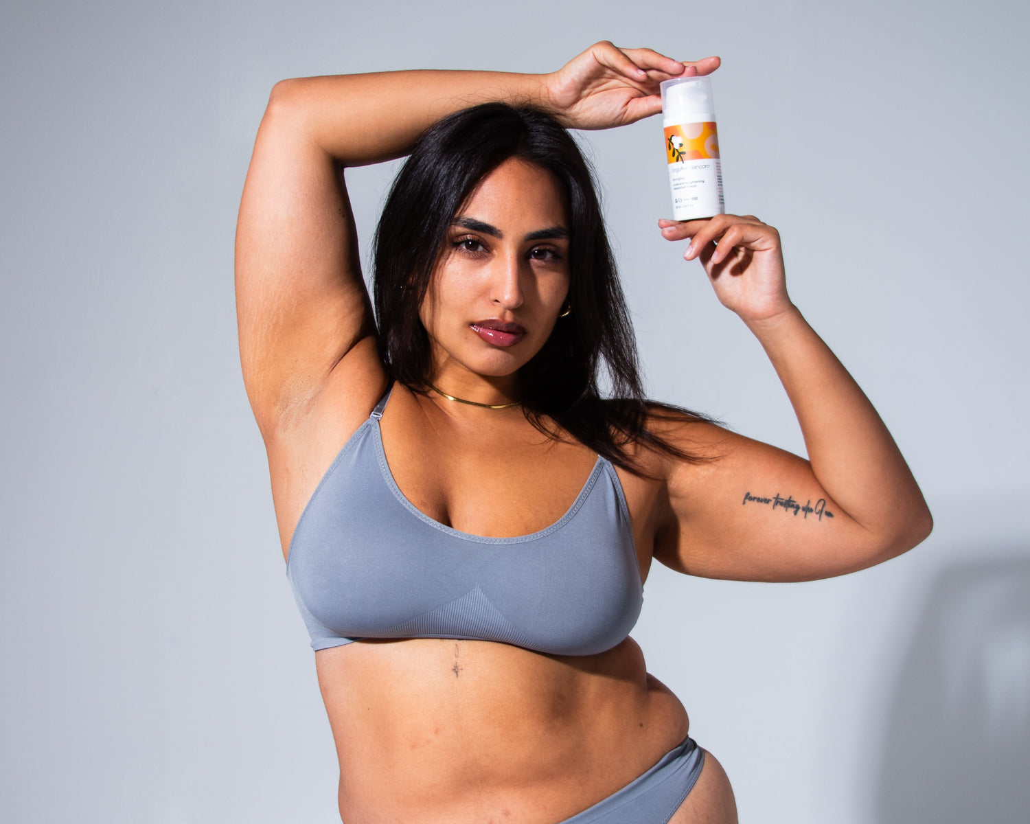 woman with bright underarms holding the original underarm brightening deodorant cream by forgotten skincare